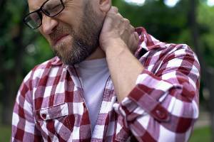 man suffering with pain in neck