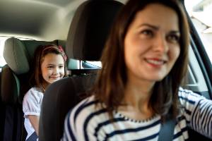 child in back seat of car smiling