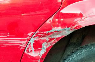 red sedan with paint damage from crash