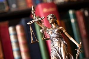 statue of lady justice by book shelf