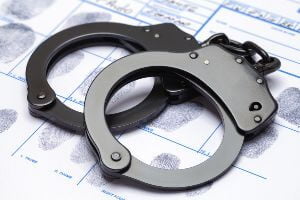 handcuffs on table with arrest forms