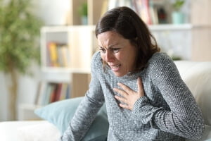 young woman clutching chest in pain