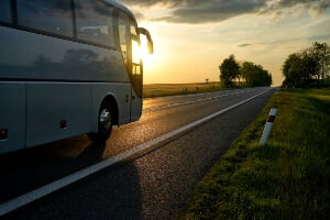 stock image of charter bus driving at sunset