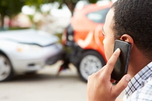photo illustration of crash victim on phone and looking at vehicle wreckage