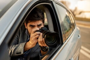 young male photographer taking pictures from vehicle
