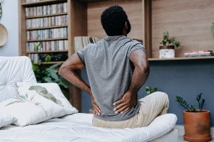 man holding lower back in pain