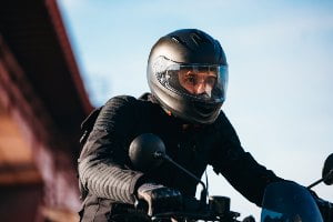 motorcyclist with black jacket riding bike