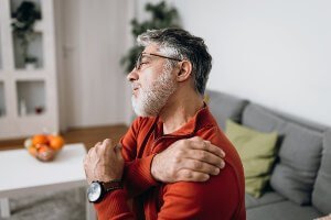 man grimacing with shoulder pain