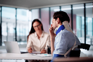female professional talking injured man