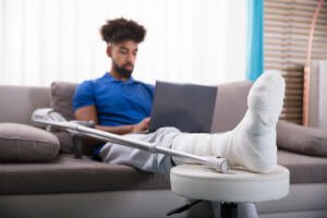 injury victim with broken leg on couch