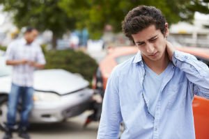 young man holding neck after a collision
