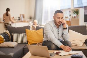 man on phone working from home on couch