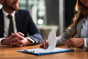 smiling people with one signing a contract